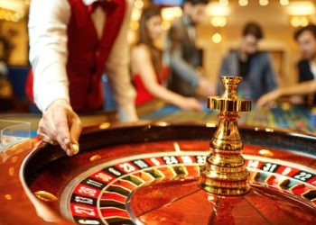 The croupier holds a roulette ball in a casino in his hand. Gambling in a casino.